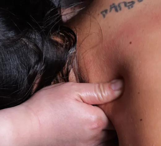 Therapeutin von NaturaMedic behandelt Nacken und Schulter einer Kundin